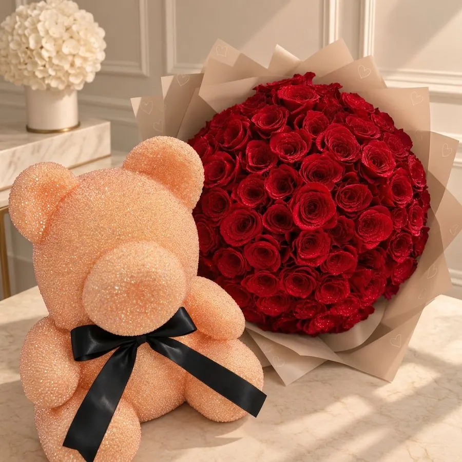 Crystal-beaded teddy bear beside a bouquet of sparkling crimson roses