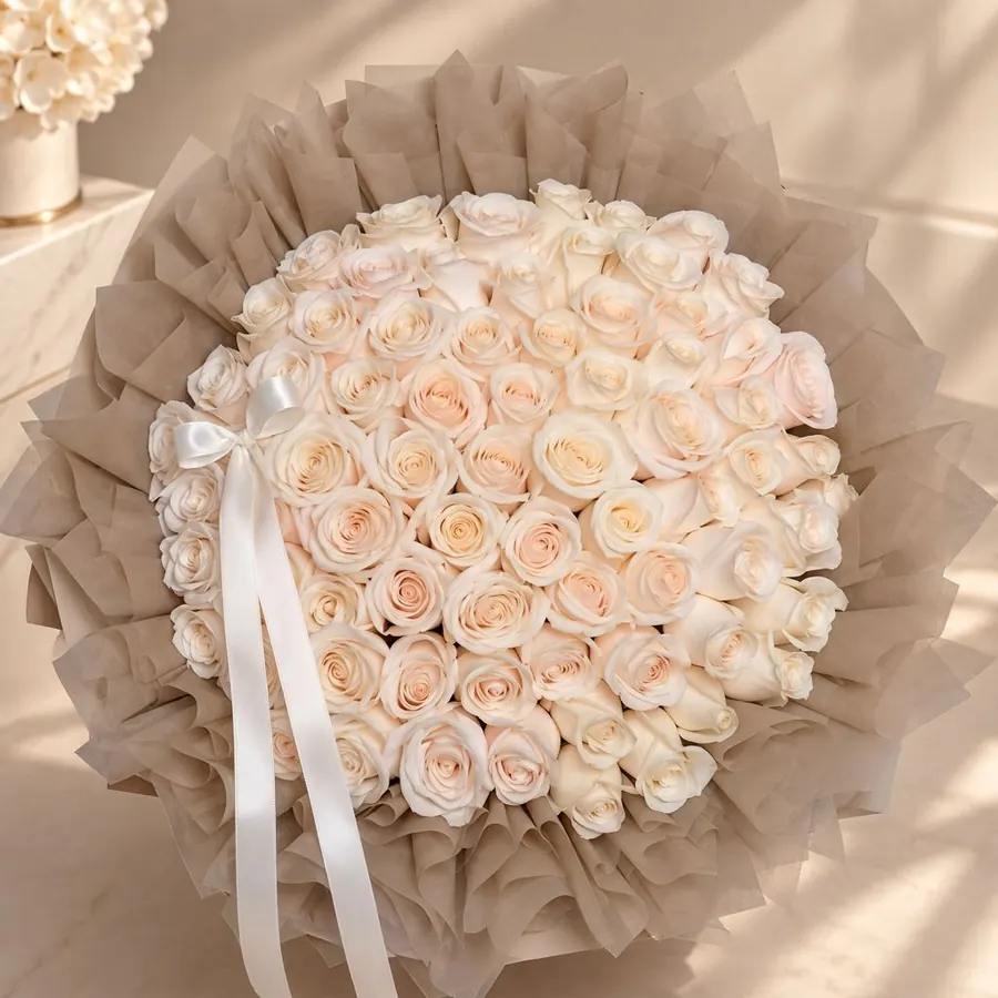 Cream and champagne rose bouquet in taupe wrapping with ivory ribbon