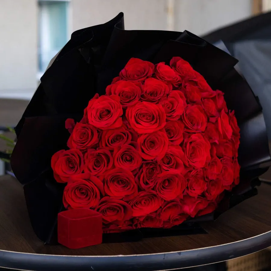 Red Obsession Bouquet - Standard - 25 roses Deluxe - 48-50 roses Premium - 73-75 roses A bold and elegant bouquet featuring vibrant red roses wrapped in striking black paper. Each flower speaks of intensity, desire, and a love that cannot be hidden. Perfect for bold declarations, anniversaries, or unforgettable proposals.
